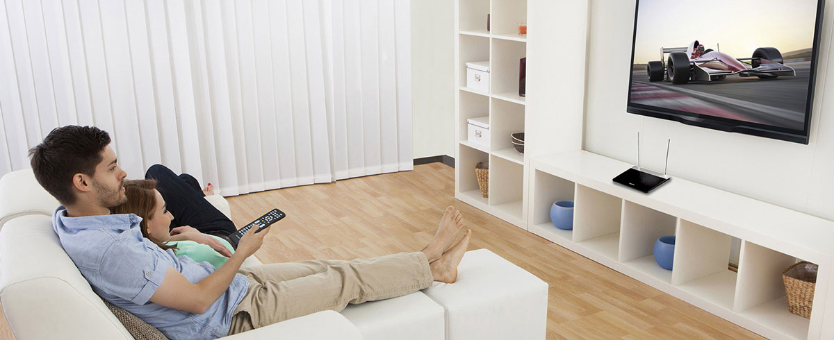 Een man en vrouw zitten op een bank en kijken naar de televisie