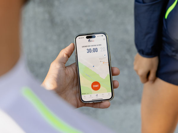 Een deelnemer kijkt op de telefoon en wacht tot de run begint.